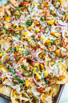 a pizza topped with lots of toppings sitting on top of a metal baking pan