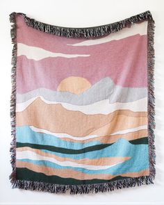 a multicolored tapestry hanging on the wall with fringes around it's edges