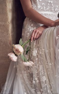 a woman in a wedding dress holding flowers