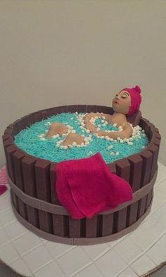 there is a cake that has a woman in the tub on it and blue frosting