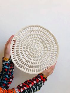 a person holding a white basket over their head