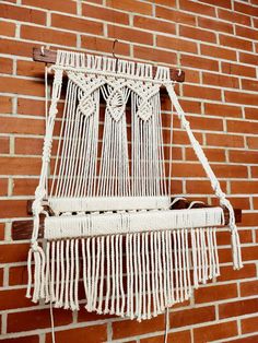 a white macrame hanging on a brick wall