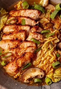 a bowl filled with chicken and noodles on top of a table