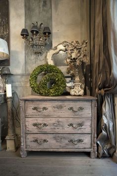 an old dresser with a wreath on top