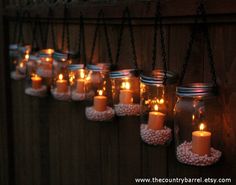 mason jars filled with lit candles hanging from chains