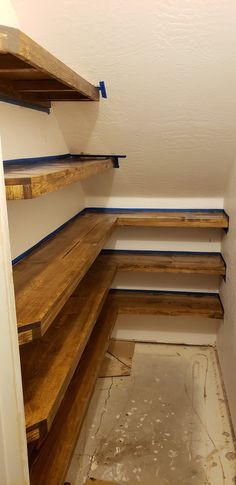 an empty room with wooden shelves and no one in the room or there is something on the floor