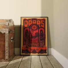 two old suitcases sitting next to each other on a wooden floor in front of a poster