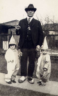 an old black and white photo of three children dressed up as clowns