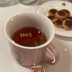 a cup of tea next to some cookies on a plate with the words star spelled in it