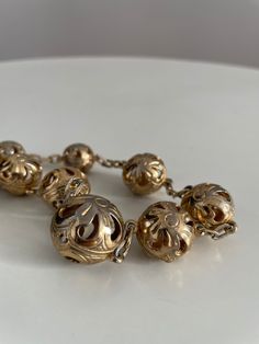 Vintage 1930s to 1940s brass necklace feature large, etched, filigree-esque balls with see-through cutouts.The balls alternate in size .  Era: 1930s -1940s Length: 20" Materials: brass , metal Condition: excellent ✩ visit the shop ✩ https://www.etsy.com/shop/Themagicstories2?ref=seller-platform-mcnav Thanks! Vintage Brass Necklace With Round Beads, Vintage Antique Gold Round Beads Jewelry, Vintage Brass Jewelry With Round Beads, Retro Gold Jewelry With Antique Finish, Vintage Gold Filigree Necklace, Vintage Metal Necklace With Round Beads, Vintage Metal Necklaces With Round Beads, Vintage Necklace With Round Metal Beads, Antique Gold Filigree Brass Necklace