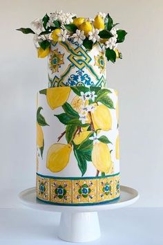 a multi layer cake decorated with lemons and flowers