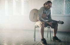 a man sitting in a chair holding a guitar