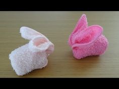 two pairs of pink and white slippers sitting on top of a wooden table next to each other