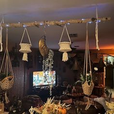 a living room filled with furniture and hanging baskets