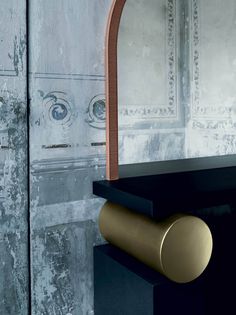 a black table with a gold handle and mirror in the background, next to a wall