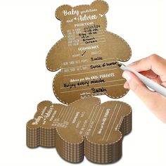 a person is writing on some brown paper with a white pen and it's attached to the back of a teddy bear shaped card