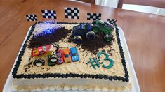 a birthday cake decorated with cars and dirt