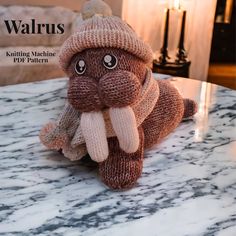 a knitted elephant sitting on top of a marble table next to a lit candle