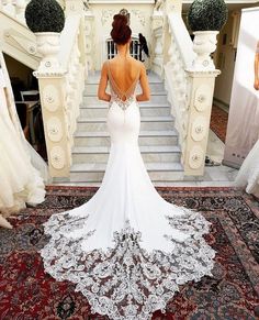 a woman in a wedding dress is standing at the bottom of stairs