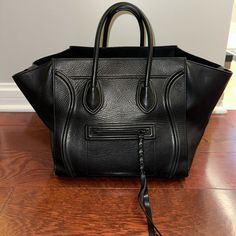 Previously Loved Authentic Celine Medium Phantom Bag In Black Pebbled Leather Length: 12 In Height: 11 In Width: 10 In Drop: 5 In High-end Black Leather Bags, Black Calf Leather Bag With Detachable Handle, Black Calf Leather Bag With Top Handle, Black Calf Leather Top Handle Bag, Black Textured Calf Leather Satchel, Black Calf Leather Shoulder Bag With Palladium Hardware, High-end Black Soft Leather Shoulder Bag, Black Calf Leather Bag With Palladium Hardware, Black Calf Leather Satchel For Daily Use