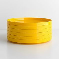 a stack of yellow plates sitting on top of a white table