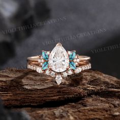 an engagement ring with pear shaped diamond and blue topazte in rose gold setting