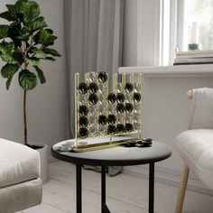 a table with wine glasses on it in front of a chair and potted plant