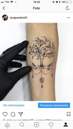 a tattoo on the arm of a person with black ink and an ornamental tree design