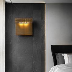 a bedroom with a black and gold wall light