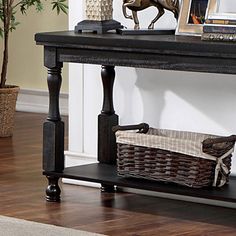 a black table with a basket on it and a wooden shelf next to the table