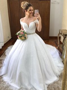 a woman is taking a selfie in her wedding dress while wearing a flower bouquet