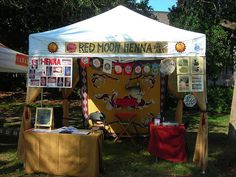 a red moon henna tent is set up in the grass for an outdoor event