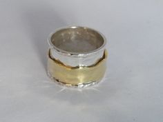 "Hammered 2 band Sterling Silver and Brass Spinner Ring- Stamped.Handcrafted.925-Custom Size What a fun little trinket to adorn your finger! This sweet little spinner ring will be hand made for you in your requested size. I hand made this band ring out of Sterling Silver and Brass. The 2 ring bands rest freely over the base band so that they can \"spin\" around. The band is approximately 15 mm(0.59 inches) wide. Size -Custom Size 8.2 grams Stamped -.925,Handcrafted When choosing your ring size p Handmade Stackable Wide Band Rings For Anniversary, Handmade Wide Band Stackable Rings For Anniversary, Unique Thick Band Jewelry Gift, Artisan Wide Band Jewelry As Gift, Unique Jewelry With Decorative Band As Gift, Unique Jewelry With Decorative Band For Gift, Unique Decorative Band Jewelry Gift, Unique Wide Band Stackable Rings As Gift, Handmade Thick Band Jewelry As Gift