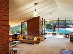 a living room filled with furniture next to a swimming pool