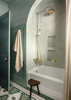 a white bath tub sitting next to a walk in shower under a faucet