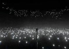 a black and white photo of fireworks in the night sky with no one around it