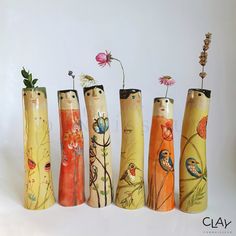 five vases with flowers and birds painted on them are lined up in a row