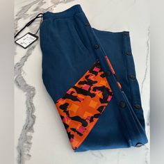 Brand New With Tags. 100% Authentic Mcm Side Snap Button Track Pants Size Xsmall Color - Navy Blue With Multicolor Insert Features Elasticized Waistband Pull-On Side Snap Button Plackets Side Slip Pockets Back Welt Pockets Geometric Print Panel 100% Cotton Hand Wash Made In Italy Measurements Rise, About 11" Inseam, About 29" Leg Opening, About 16" Comes Exactly As Shown In Photos. Blue Bottoms With Buttons For Loungewear, Orange Logo, Nylon Joggers With 4-way Stretch And Pockets, Side Snap, Classic Logo, Jogger Sweatpants, Side Stripe, Green Cotton, Winter Women