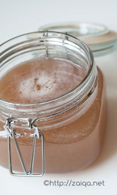 a jar filled with brown liquid sitting on top of a table