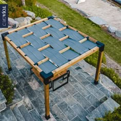 an outdoor table made out of blue tarp and wooden slats on top of stone steps