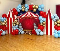 a circus themed birthday party with balloons and decorations on the floor in front of an arch