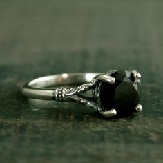 a black diamond ring sitting on top of a wooden table