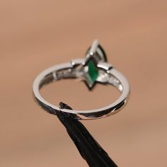 It is a lab emerald ring. The main stone is 5mm*10mm marquise cut, weight about 0.82 carats. The basic metal is sterling silver and plated with rhodium. To change the metal to a solid gold (white/rose) or platinum is also available, please ask for a quotation if you want. You can also go to my shop Home for more elegant rings: https://www.etsy.com/shop/godjewelry?ref=hdr_shop_menu More emerald rings: https://www.etsy.com/shop/godjewelry?section_id=20709240 Customization is always welcome and ple Marquise Emerald Ring With Center Stone, Marquise Emerald Ring For May Birthstone, Green Marquise Cut Emerald Promise Ring, Marquise Emerald Ring For Promise In May, Marquise Cut Green Emerald Ring With Prong Setting, Green Emerald Marquise Cut Ring With Prong Setting, Marquise Cut Emerald Promise Ring, Emerald Marquise Promise Ring For May Birthstone, Marquise Cut Emerald Wedding Ring