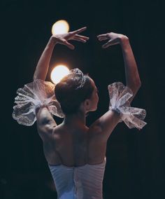 a woman in a white dress is doing ballet