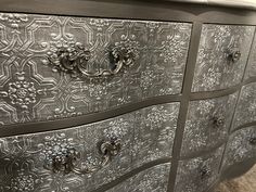 an ornate silver dresser with metal handles and knobs on it's drawers is shown