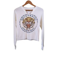 Nwt Women's Tigers University Notch Neck Long Sleeve Cropped Graphic T-Shirt Brand: Zoe + Liv Multicolored Size: Xs Material: 60% Cotton / 40% Polyester Measurements Are Approximate And Taken Laying Flat And Unstretched; *Underarm - Underarm 18" = Bust 36" *Length 21" *Arm Length 20" Orders Ship Next Business Day. Spring Collegiate Graphic Print Tops, Sporty Stretch Top With Screen Print, White V-neck Top For College, Collegiate Crew Neck Stretch Top, Graphic Print Stretch Top For Loungewear, Stretch Graphic Print Top For Loungewear, Collegiate Spring Graphic Print Tops, Fitted Collegiate Top With Graphic Print, Collegiate Letter Print Tops For Loungewear