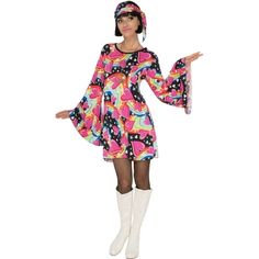 a woman in a colorful dress and white boots is posing for the camera with her hands out