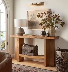 a living room with a couch, table and vase on the floor in front of a window