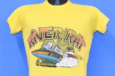 Chest 16 in.  Length 25.5 in.   Tag Says: S, 50/50 Cotton/Polyester, Made in USA  This shirt was designed for proud River Rats, who love a day spent out on the water. The colorful cartoon graphic on this tee is a great example of popular 70s t-shirt imagery. The zany look of the cartoon rat is in line with the Kustom Kulture graphics from that era, and this character is reminiscent of Big Daddy Roth's famous Rat Fink.   Comments: Fits like a modern unisex adult small, spot on the front and some Summer Boating T-shirt With Short Sleeves, Summer Short Sleeve T-shirt For Boating, Summer Boating T-shirt With Crew Neck, Summer Crew Neck T-shirt For Boating, Graphic Print Short Sleeve Tops For Boating, Graphic Print Crew Neck T-shirt For Boating, Crew Neck Top With Letter Print For Boating, Cartoon Rat, River Rat