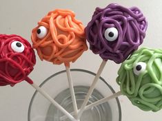 four colorful lollipops with googly eyes on them